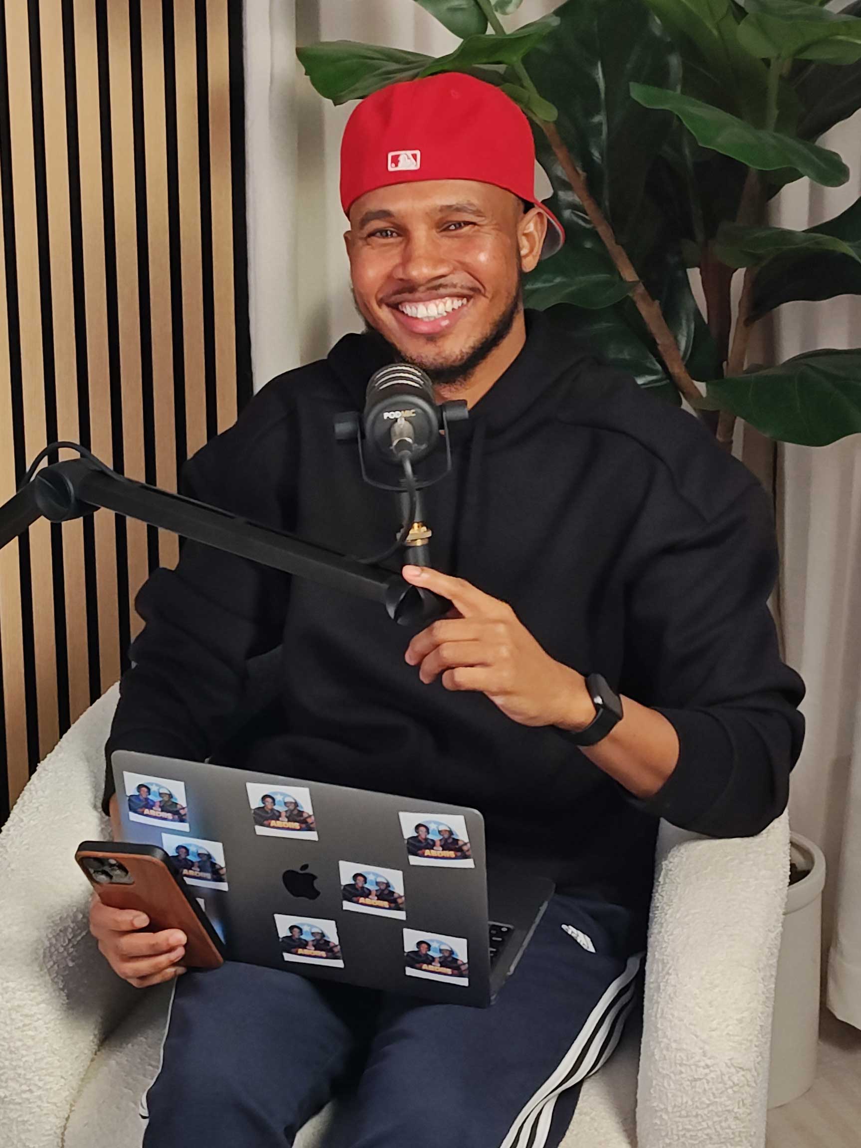 Abdul adjusting his microphone during his podcast session.