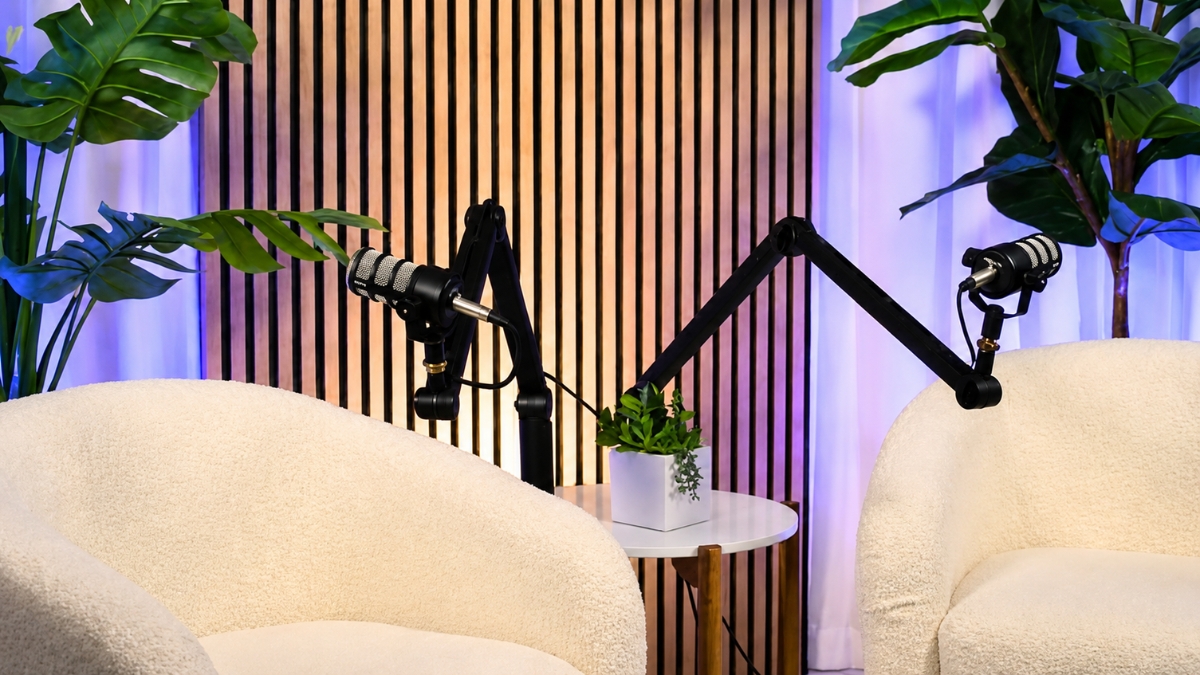 Empty two person set with dual white chairs slatted wall with white curtains and light purple backlighting.